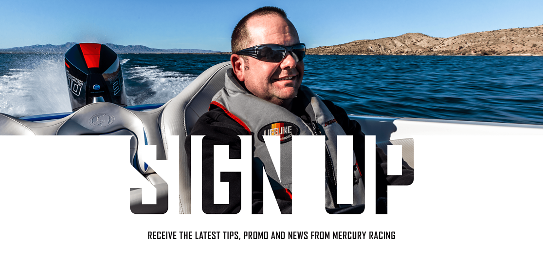 An image with a man smiling will driving a boat with a black and red Mercury Racing 300R outboard with water in the background.